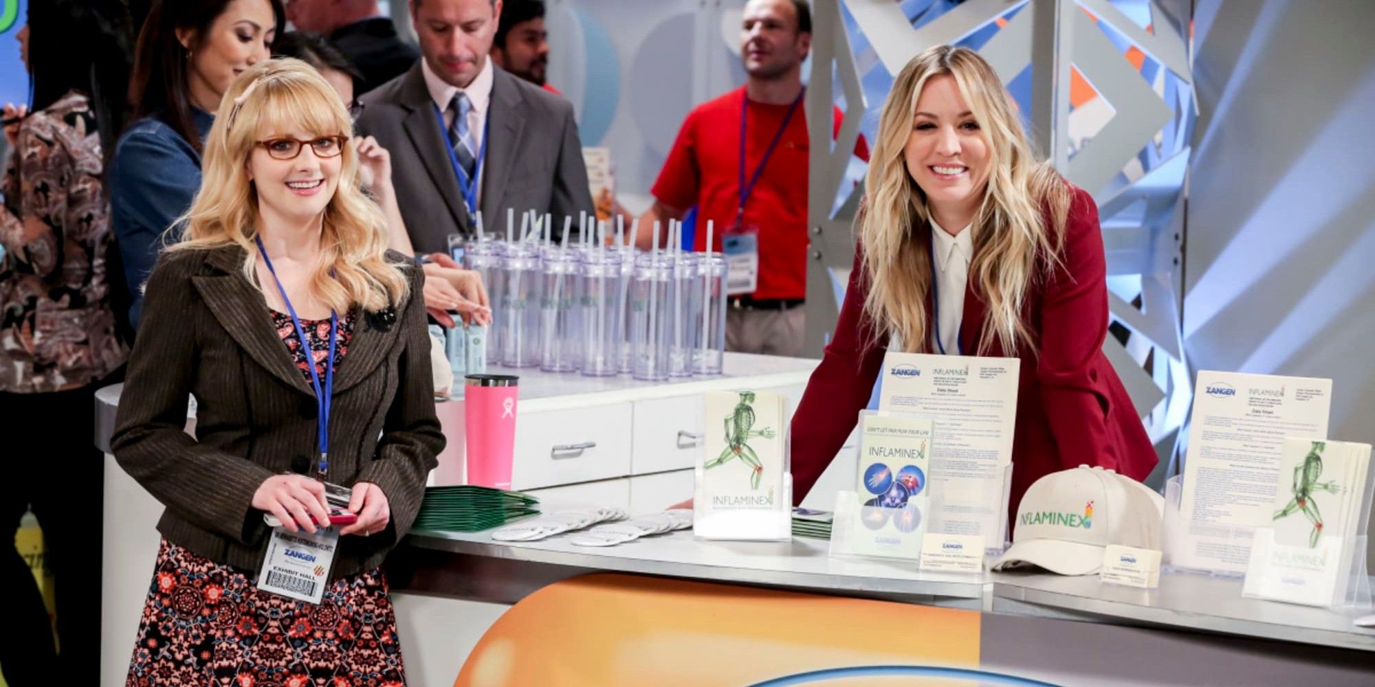 Penny and Bernadette at a work convention smiling at the camera in TBBT