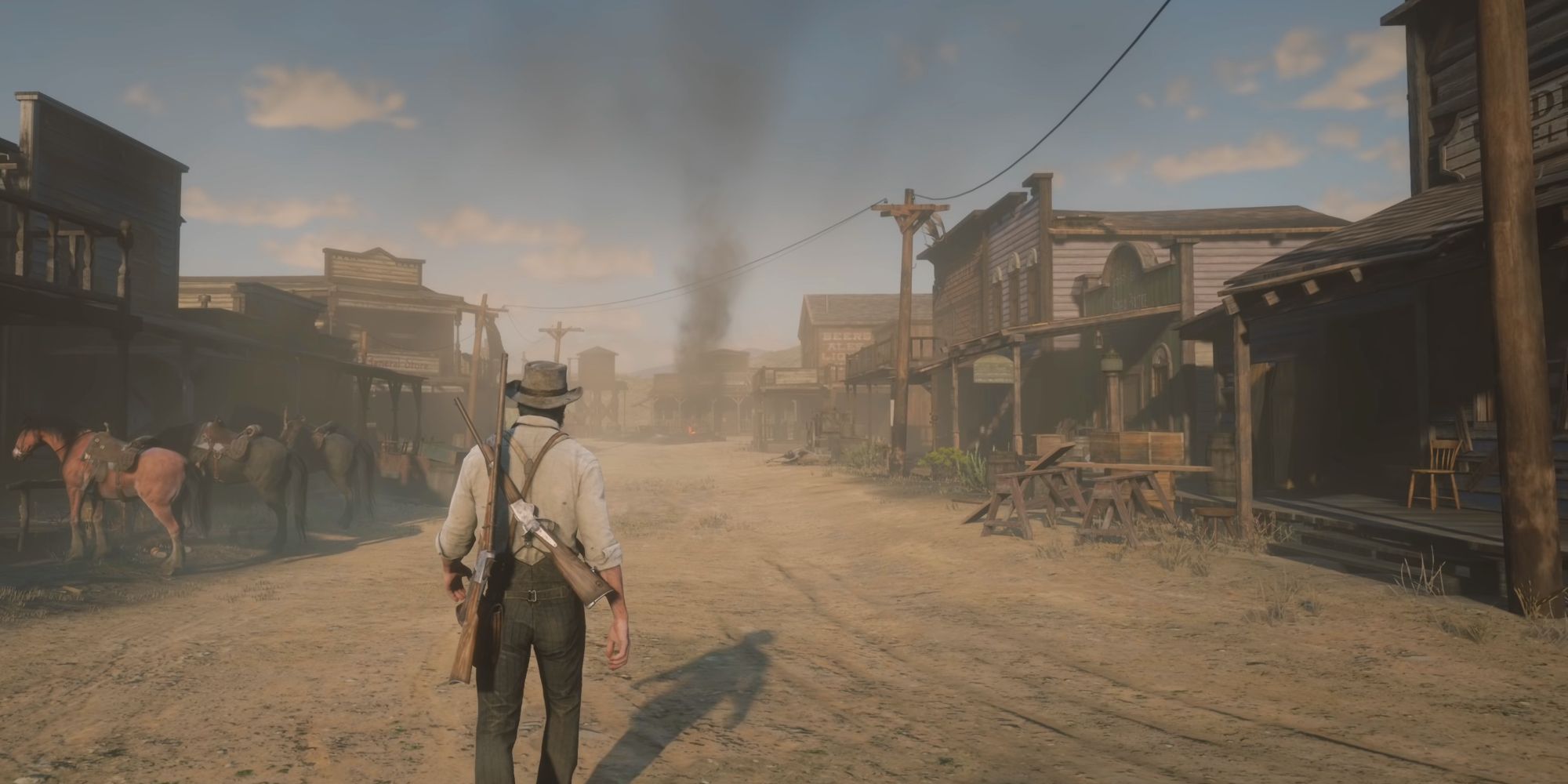 John Marston standing in the center of the road in Armadillo in Red Dead Redemption 2