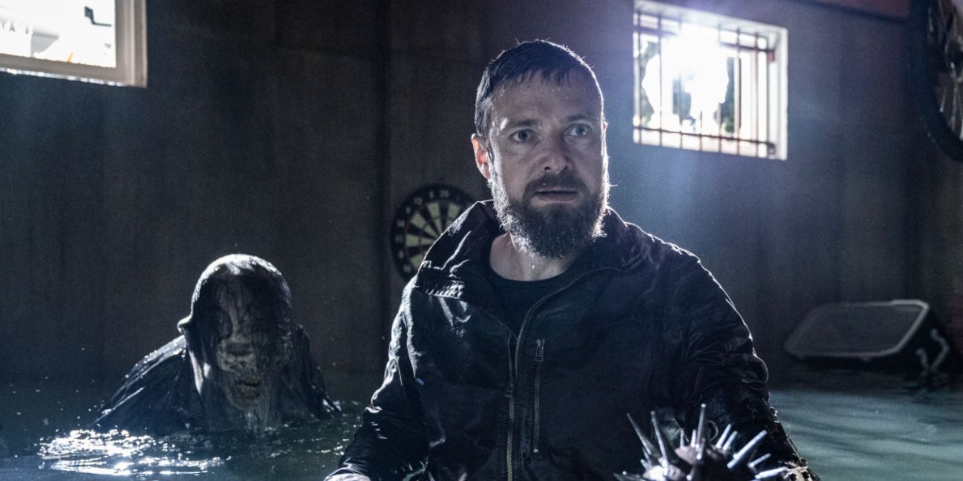 Aaron in a flooded basement with a walker in The Walking Dead