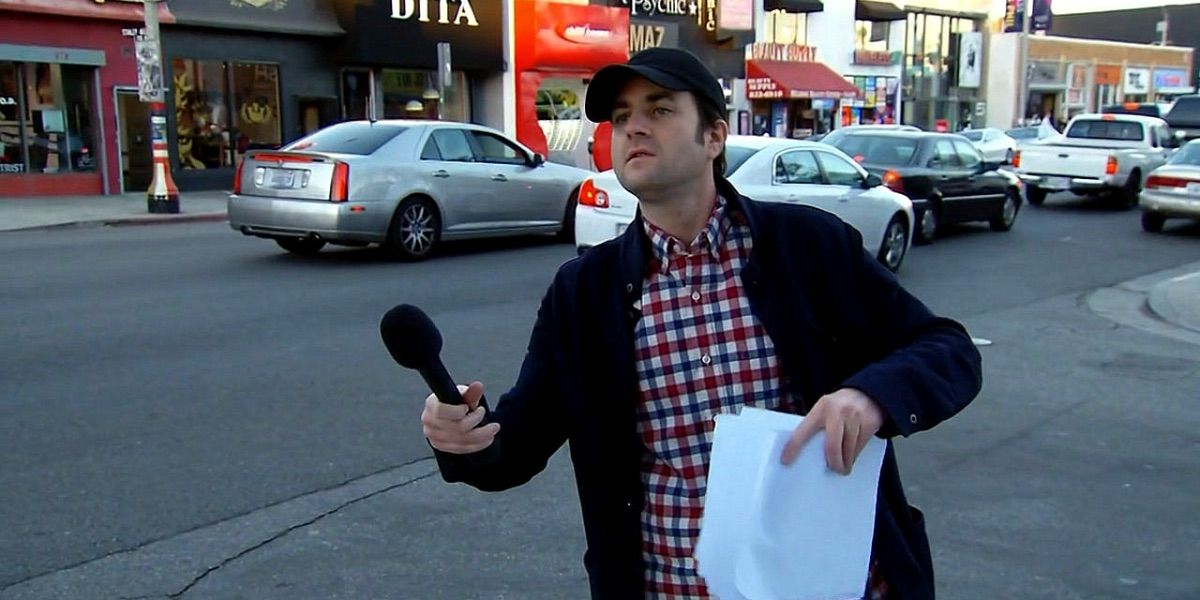 Ben Hoffman holds a microphone on the street from The Ben Show