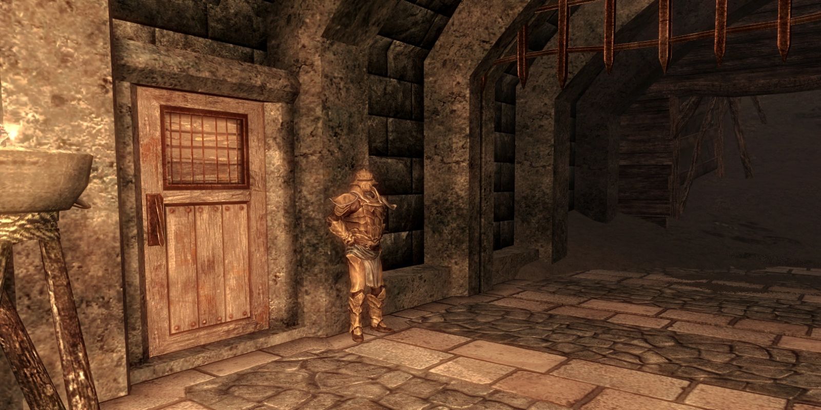 A guard standing next to a jail cell door in Skyrim's Bulwark Jail.