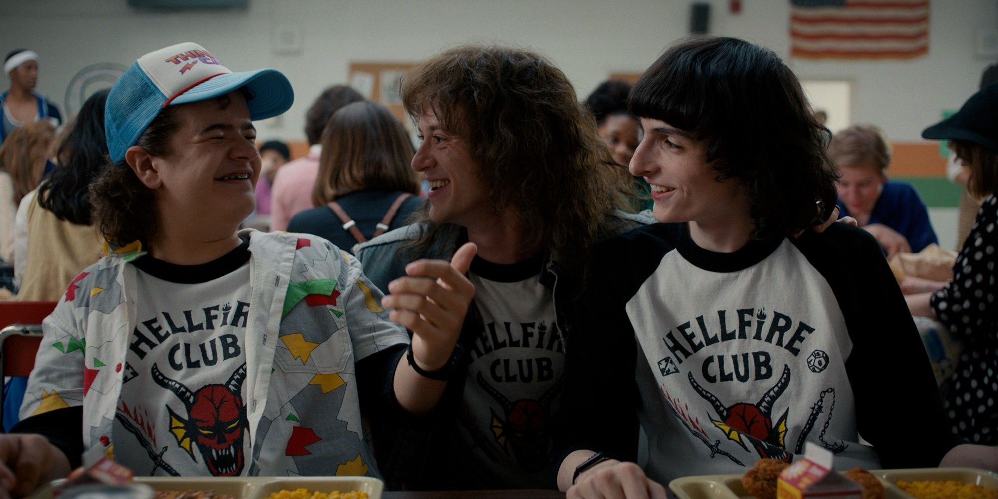 Gaten Matarazzo as Dustin and Finn Wolfhard as Mike laughing with Joseph Quinn as Eddie Munson in Stranger Things