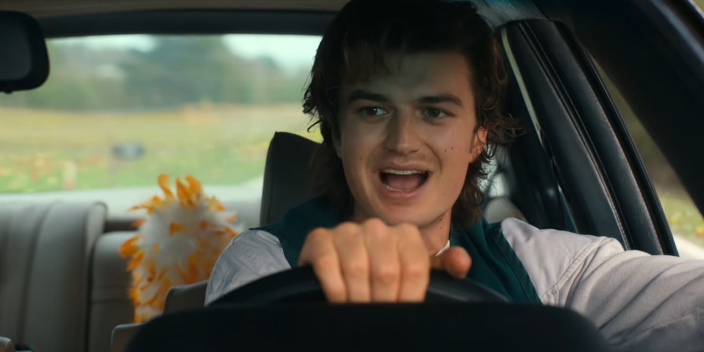 Steve driving his car hand on the wheel, mouth open in a scene from Stranger Things.