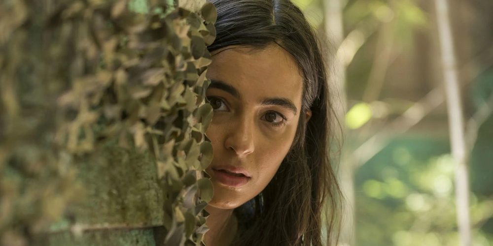 Tara hiding behind a tree in The Walking Dead 