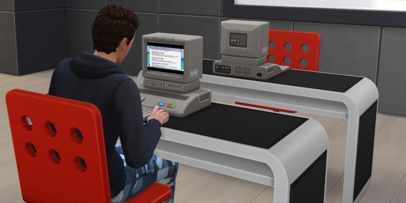 A male sim using a computer in The Sims 4.
