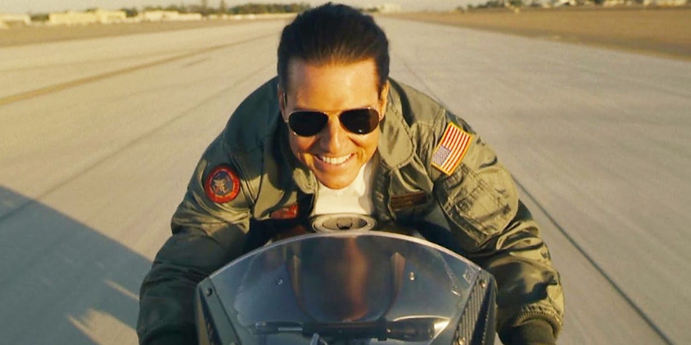 Tom Cruise smiling while riding a motorcycle in Top Gun: Maverick