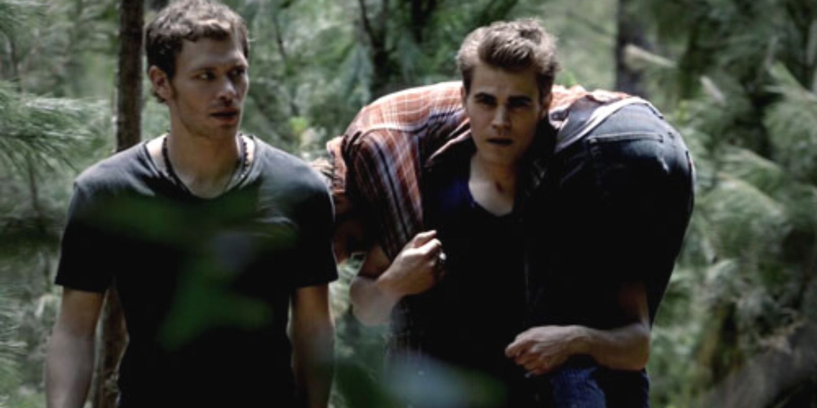 Stefan carries someone in the woods with Klaus