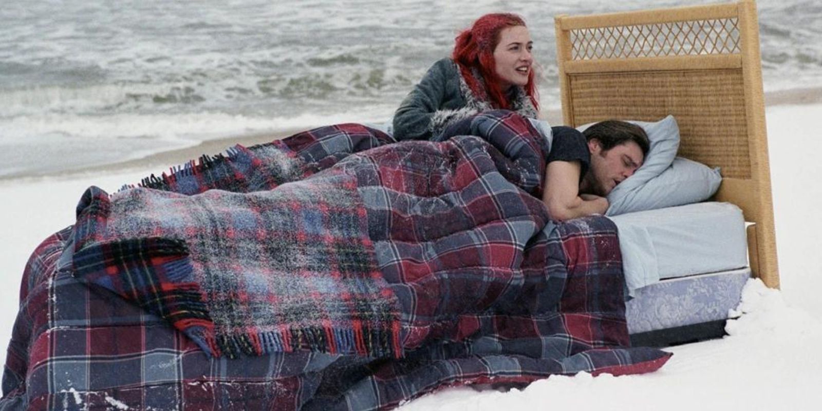 Joel and Clementine laying on a bed outside in the snow