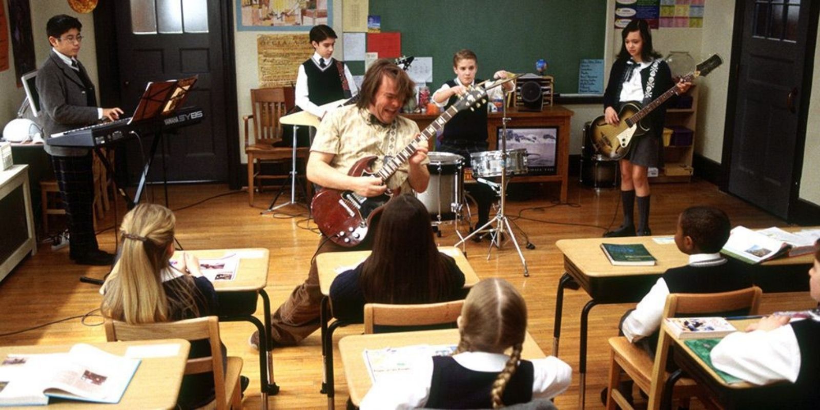 Dewey rocks out with his guitar in front of students