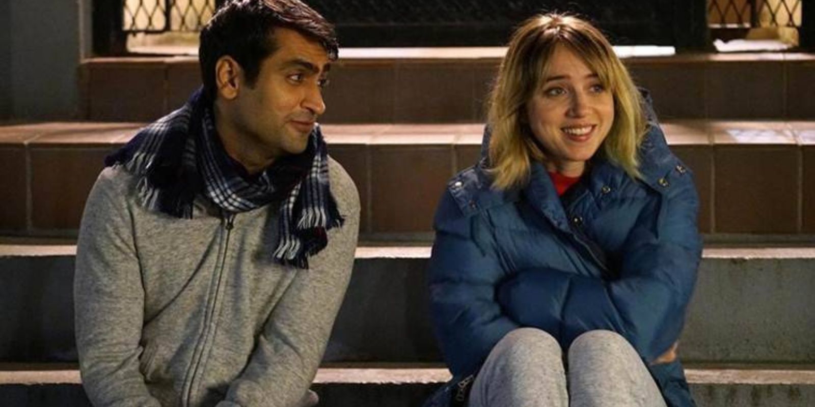 Kumail and Emily sit on steps at night