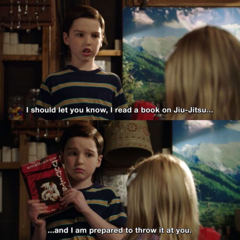 Sheldon holding up a book while talking to Missy in Young Sheldon