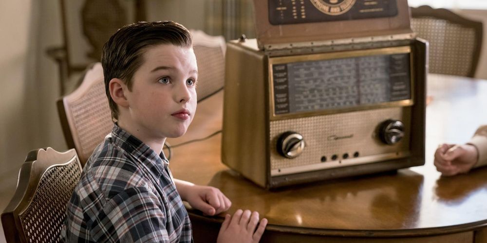 Sheldon sits by a radio at the dinner table in the season 2 finale of Young Sheldon
