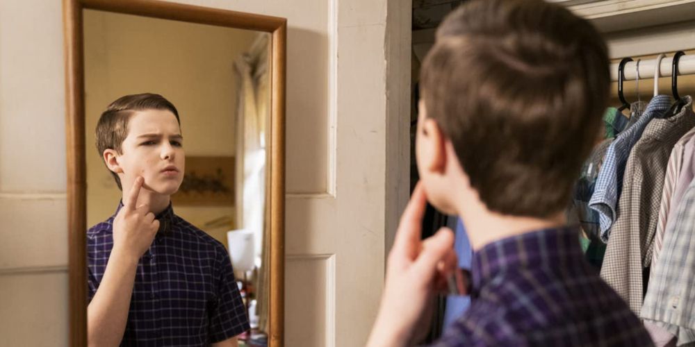 Sheldon examine a pimple in the mirror in the season 5 finale of Young Sheldon