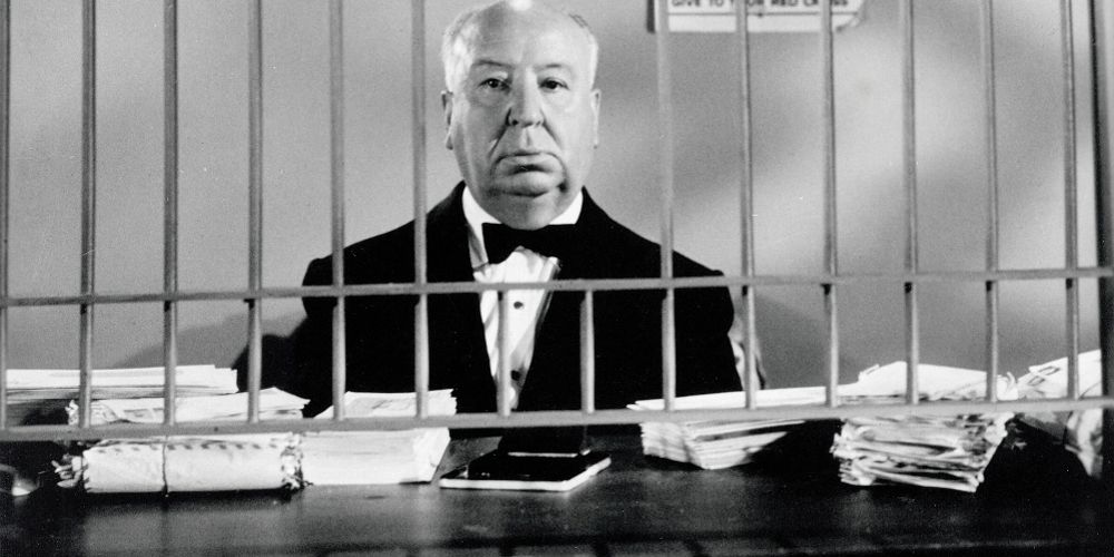 Alfred Hitchcock stands behind bars in Alfred Hitchcock Presents