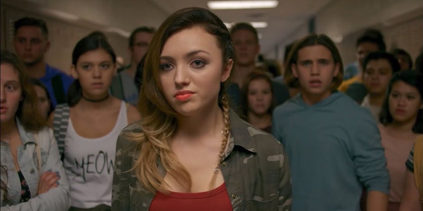 Tory from Cobra Kai standing in the school hallway with a group of students behind her