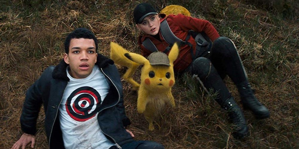 Tim, Pikachu, and Lucy look sit on the ground and look up in Pokemon Detective Pikachu