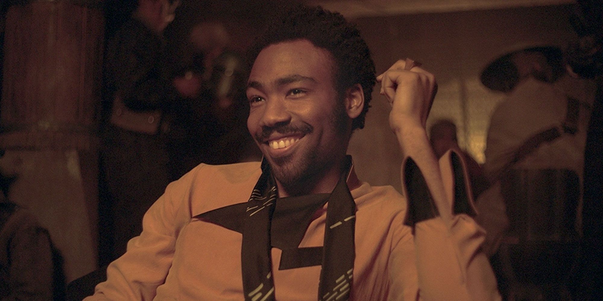 Um jovem Lando Calrissian sorri. 