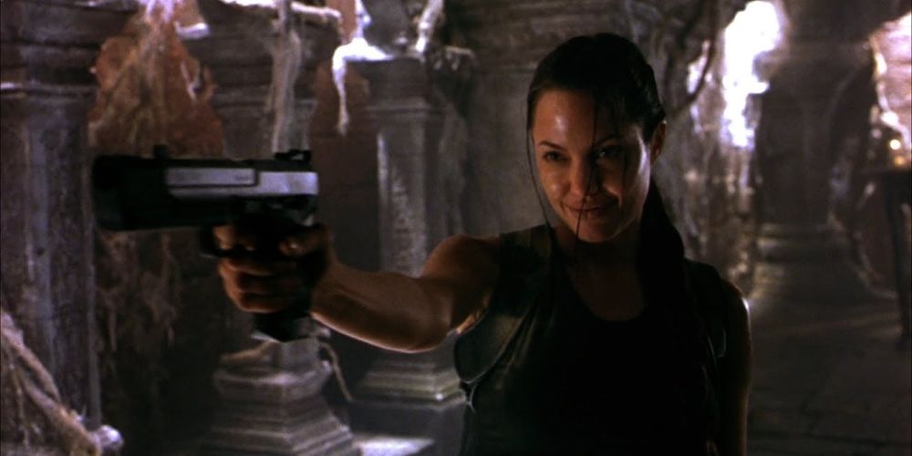 Lara points a gun and smiles in Lara Croft: Tomb Raider