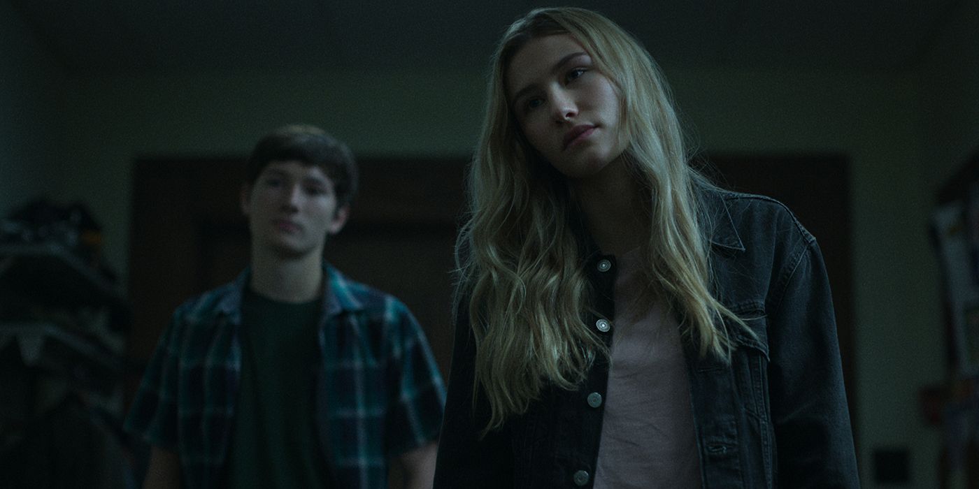 Charlotte from Ozark looking at something, Jonah in the background.