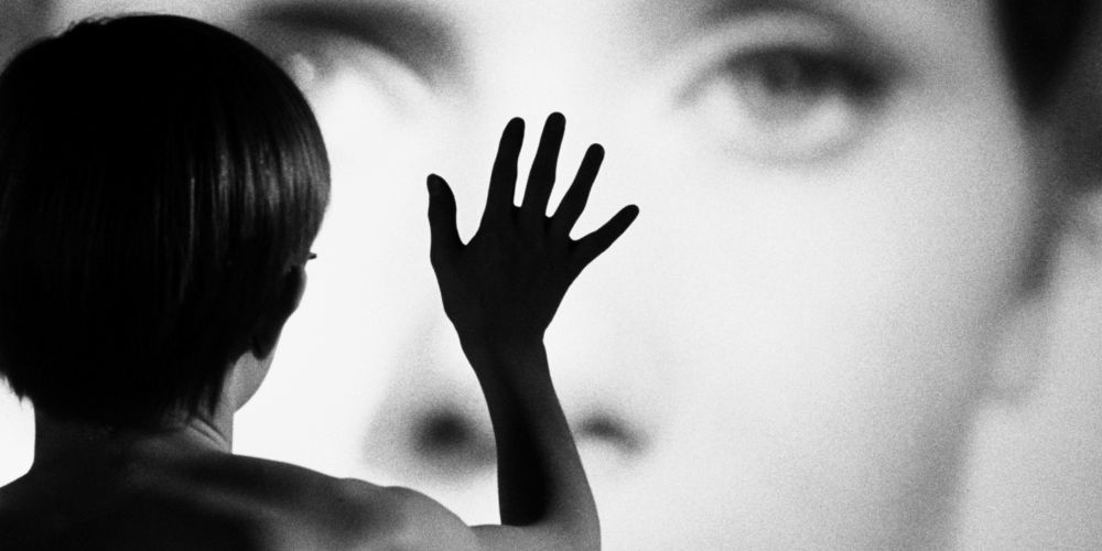 A woman with her hand on a screen in Ingmar Bergman's Persona