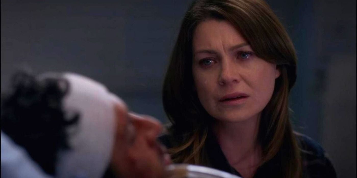 Meredith Grey crying, sitting beside Derek Shepherd's hospital bed on Grey's Anatomy