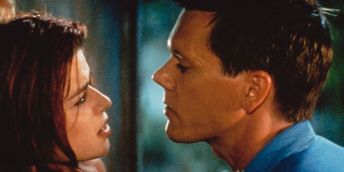 Neve Campbell and Kevin Bacon staring at each other in a still from Wild Things.