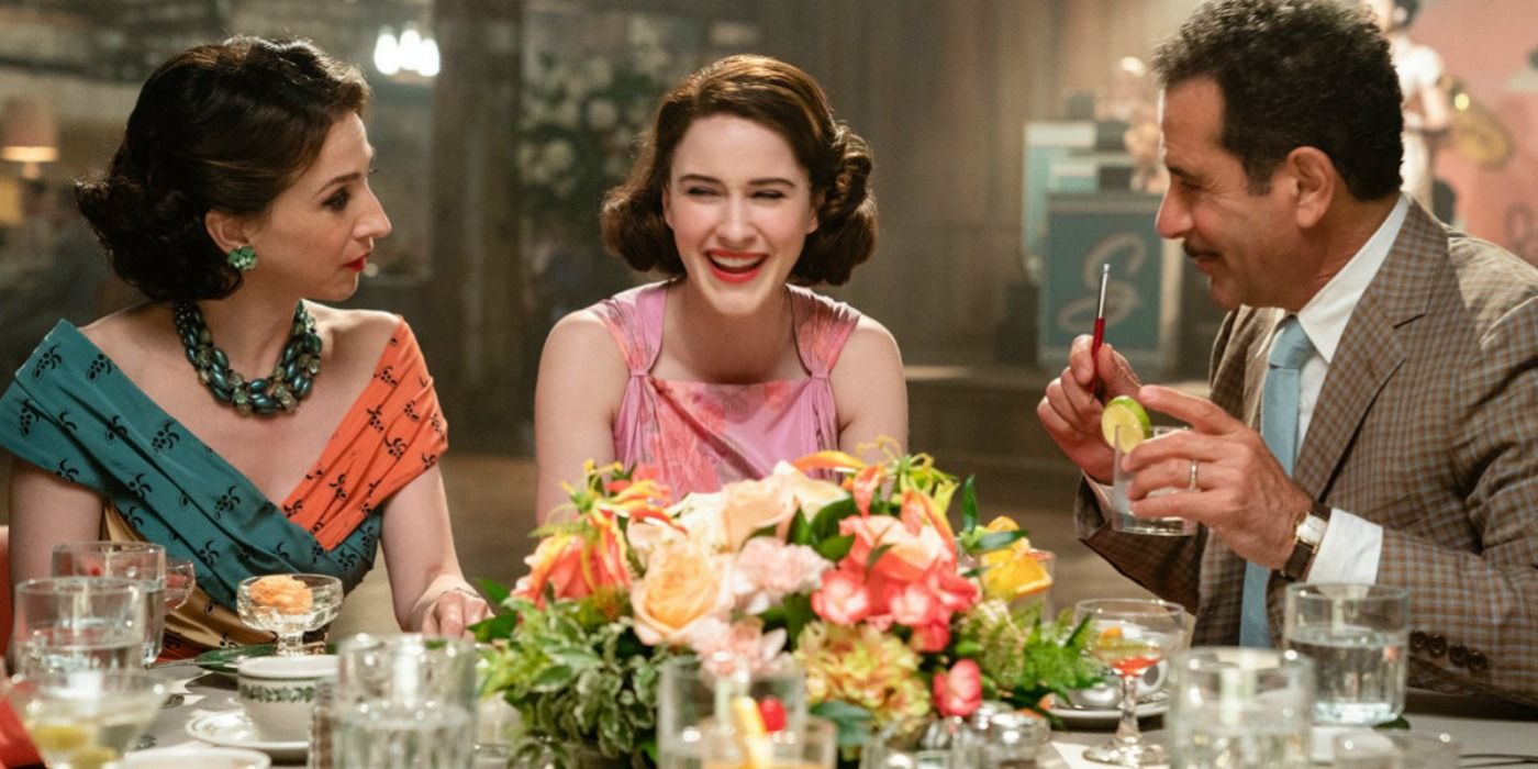 The Weissman family sitting at a table laughing in The Marvelous Mrs. Maisel