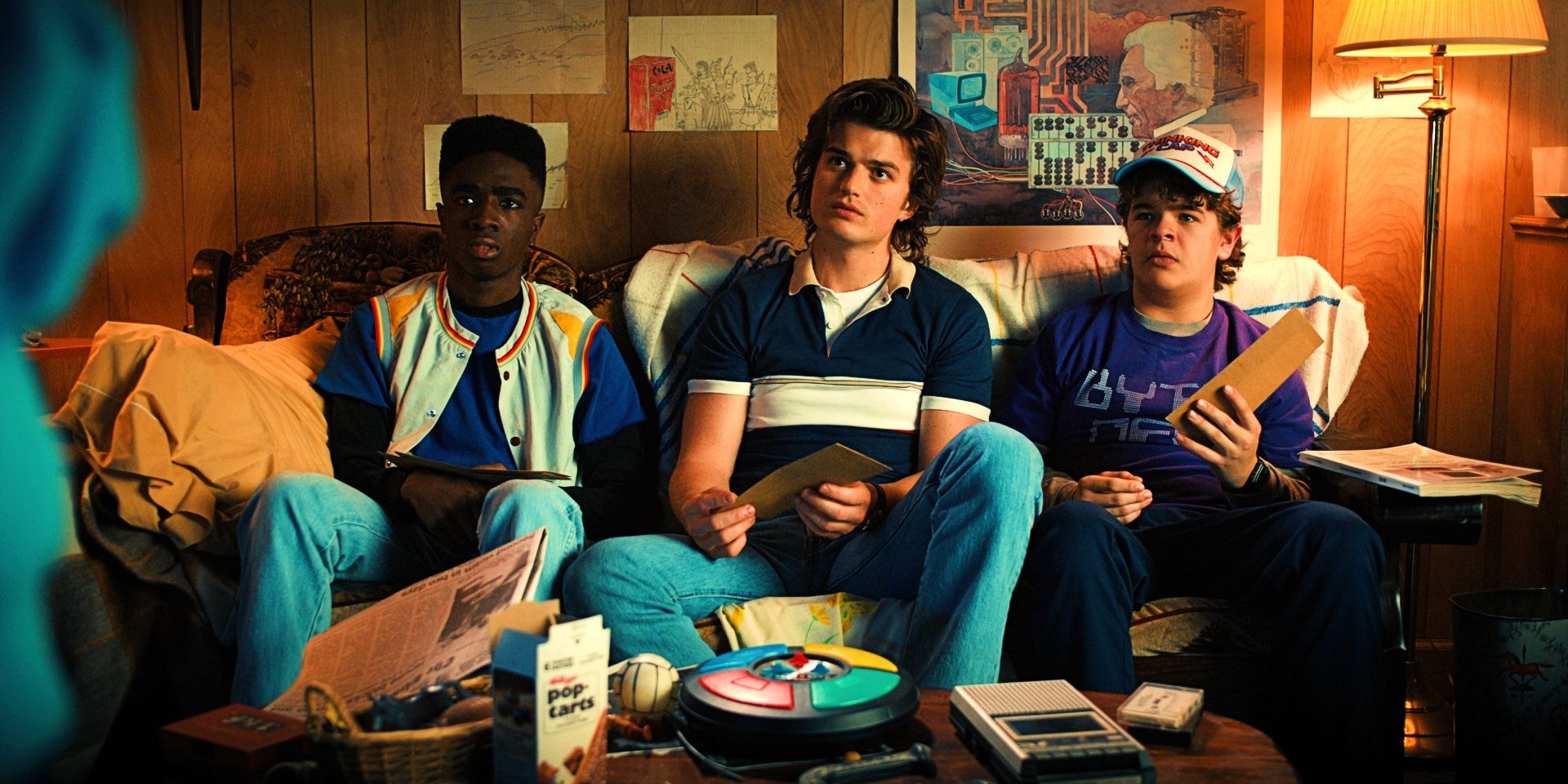 Lucas, Steve, and Dustin on the couch in Stranger Things season 4