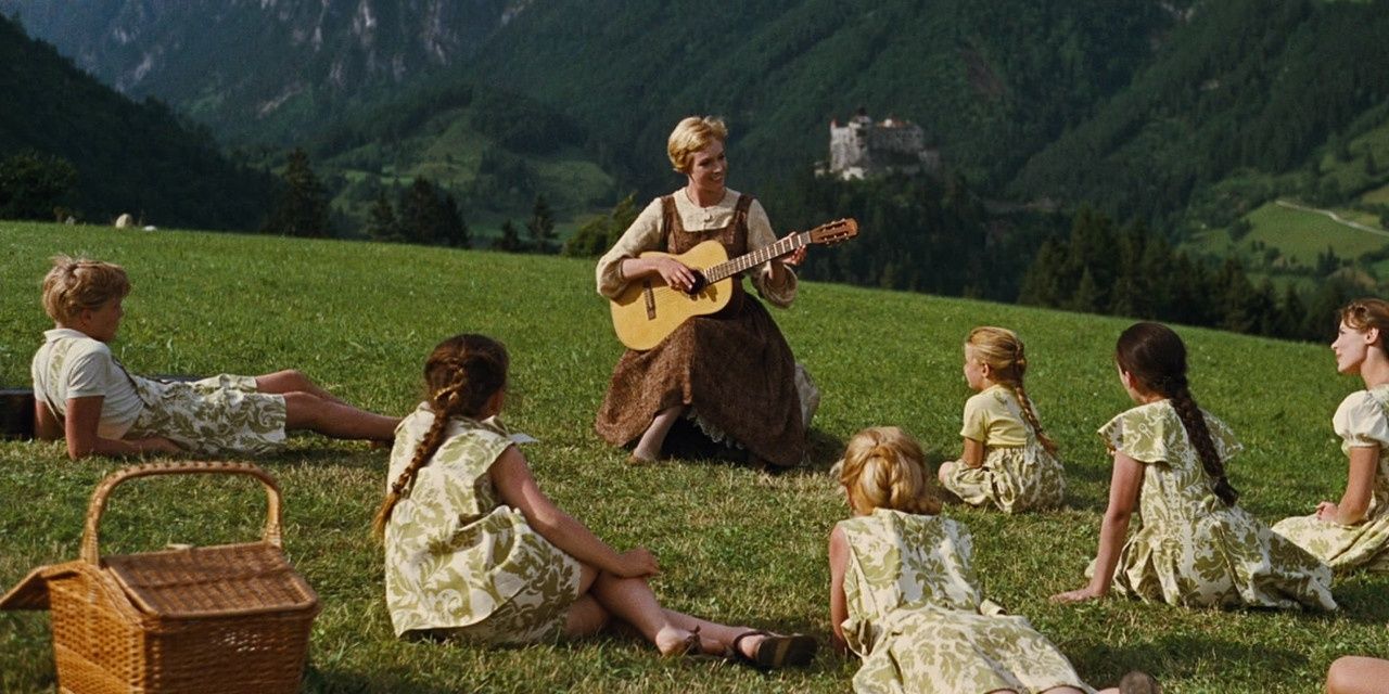 Maria tocando violão e cantando para as crianças von Trapp em um parque em The Sound of Music