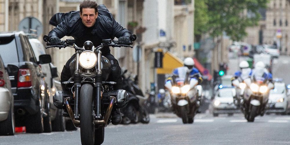Ethan rides a motorcycle down the street in Mission: Impossible - Fallout