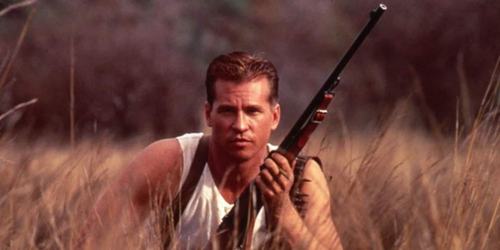 Patterson kneels with a rifle in the grass in The Ghost and The Darkness
