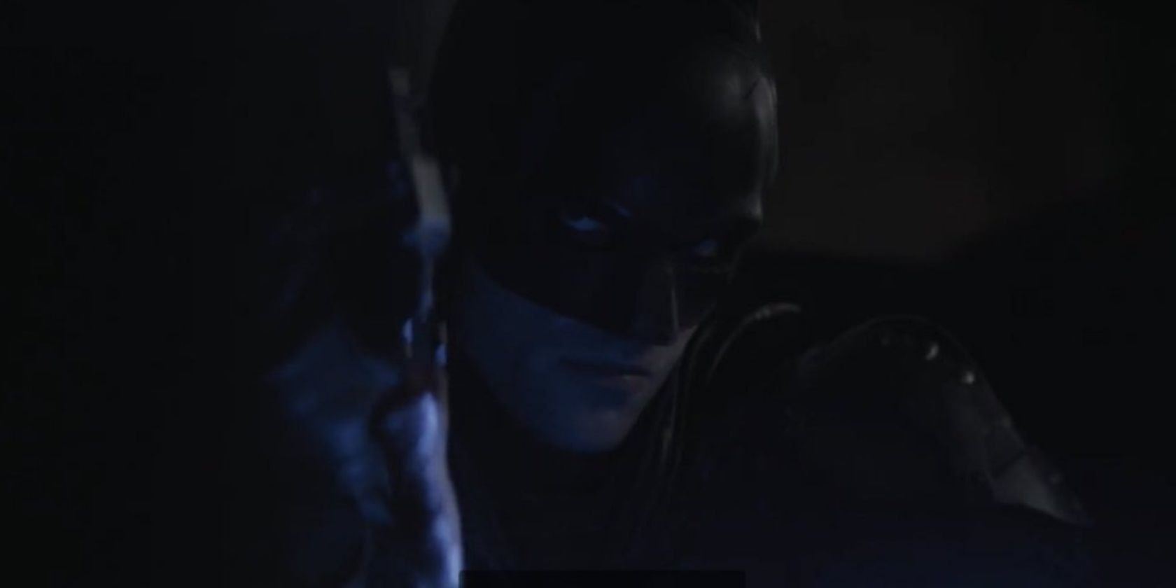 Batman holds the thumb drive in The Batman