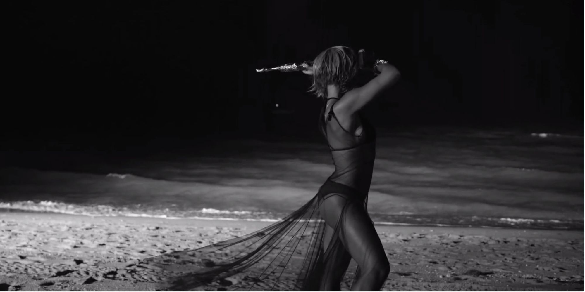 Beyoncé with a trophy on the beach in the Drunk in Love video