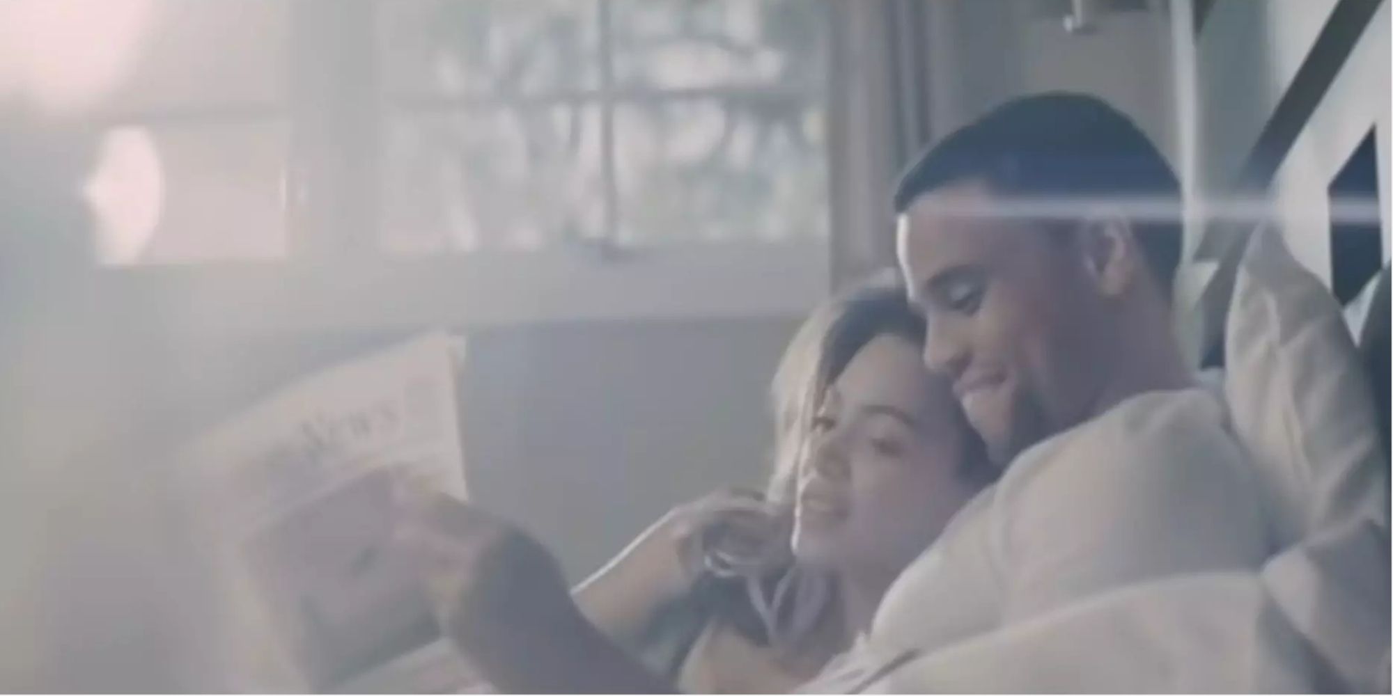 Beyoncé and Michael Ealy reading a newspaper in bed in the Halo video