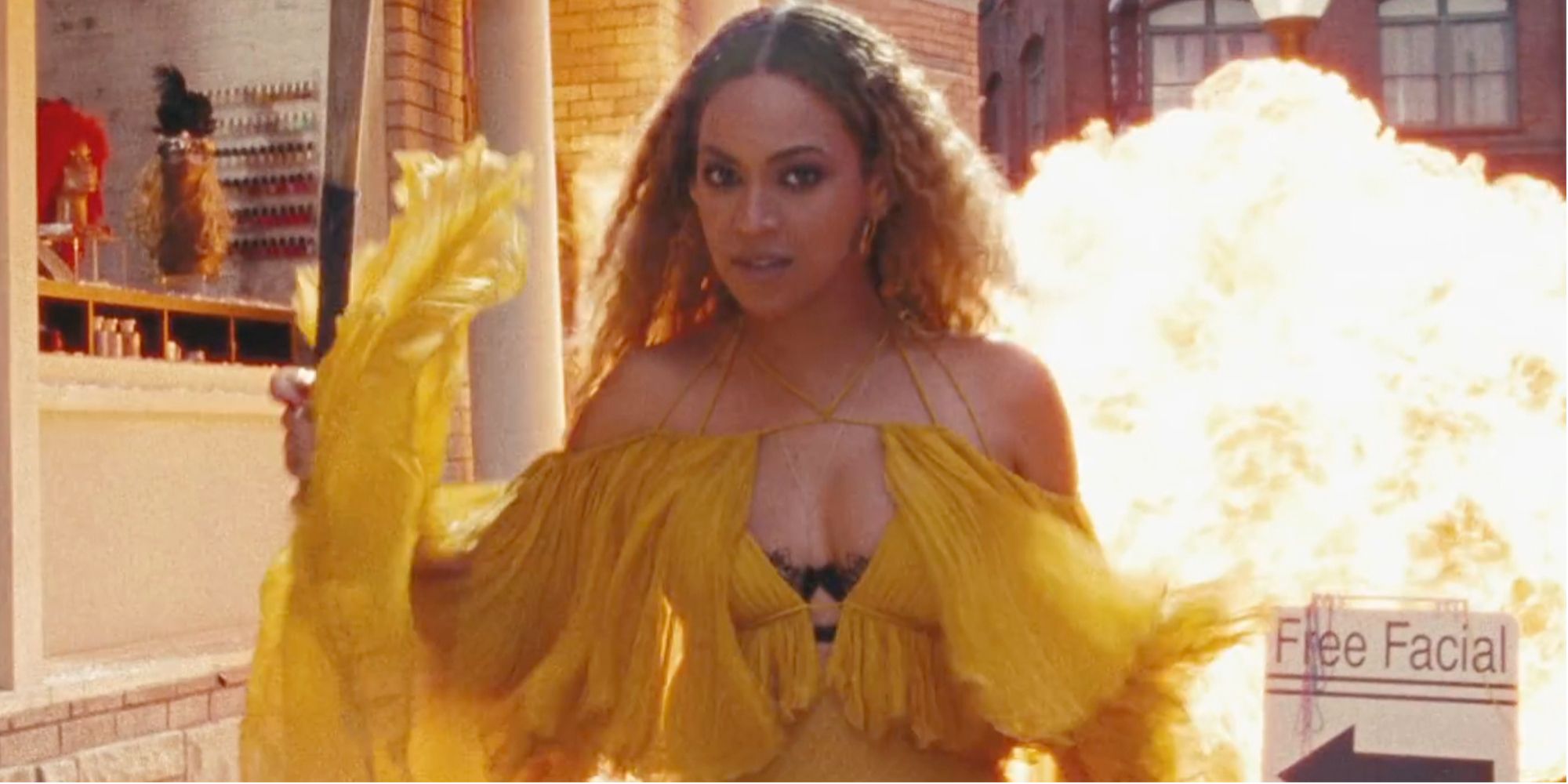 Beyoncé holding a bat with an explosion behind her in the Hold Up video