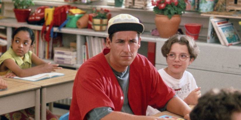 Adam Sandler as Billy Madison sitting at a desk in a classroom.