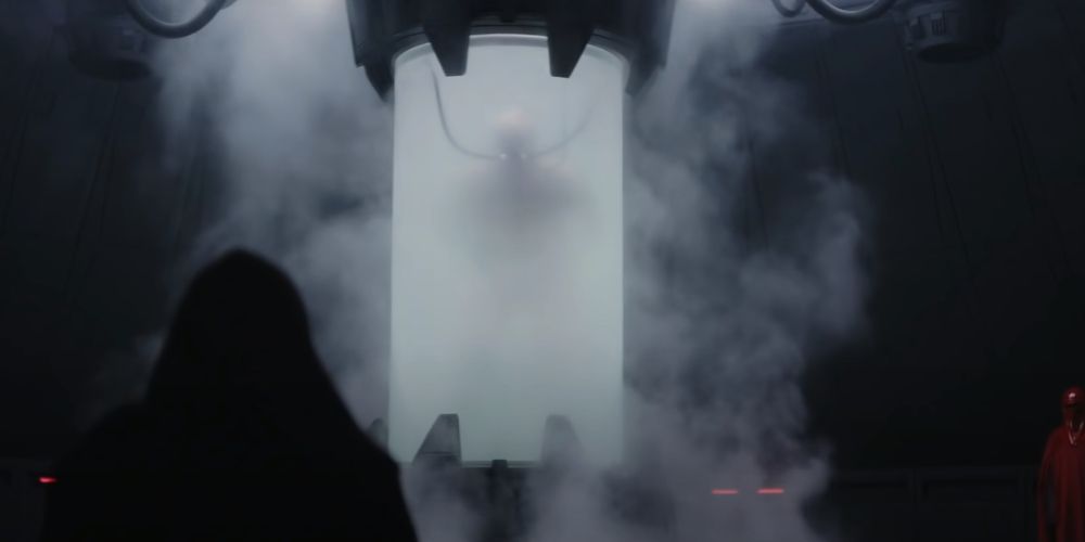 The steam clears revealing the first glimpse of Darth Vader in his Bacta Tank guarded by Imperial Guards and with an underling kneeling before him in Star Wars Rogue One