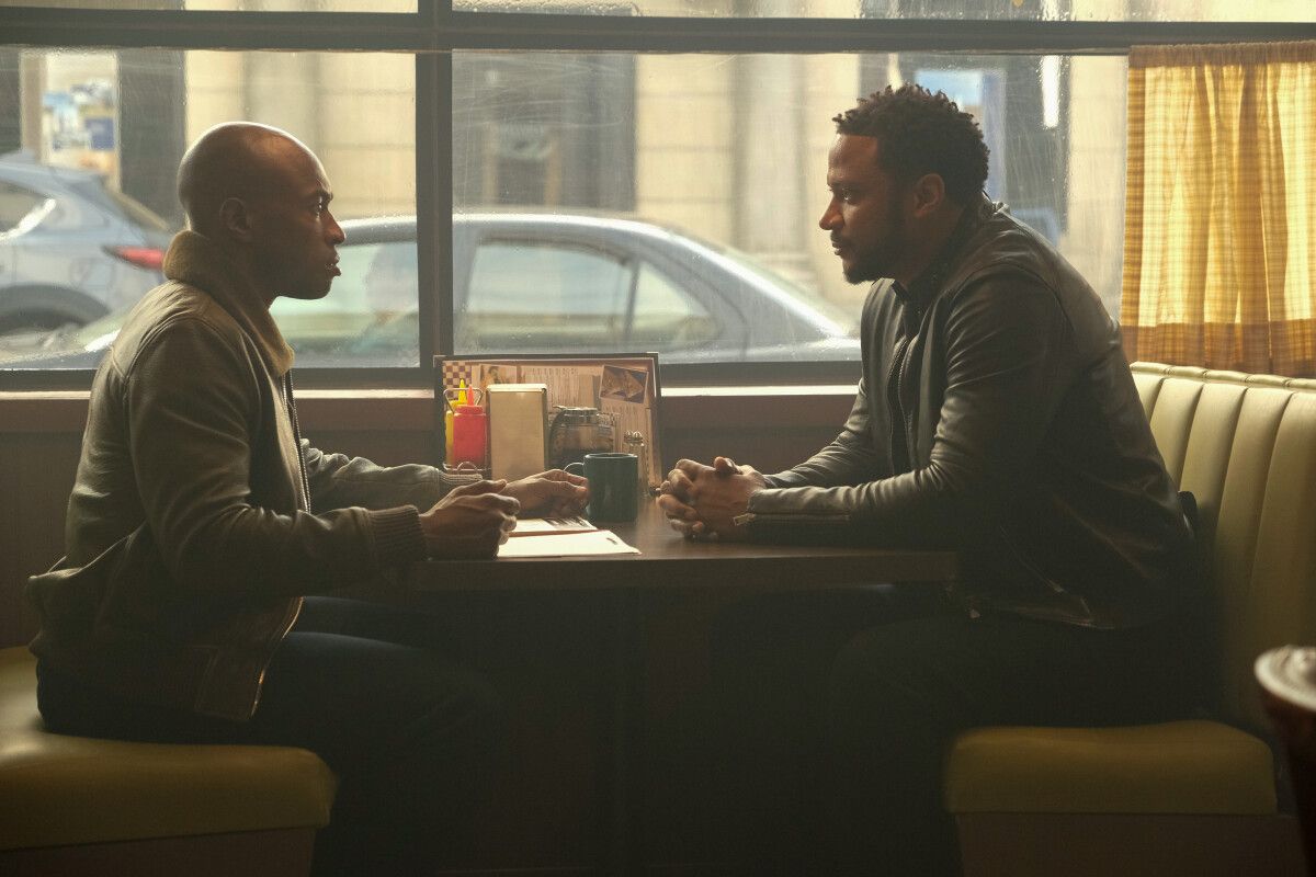 David Ramsey as John Diggle and Wole Parks as John Henry Irons talking in a booth in Superman and Lois season 2