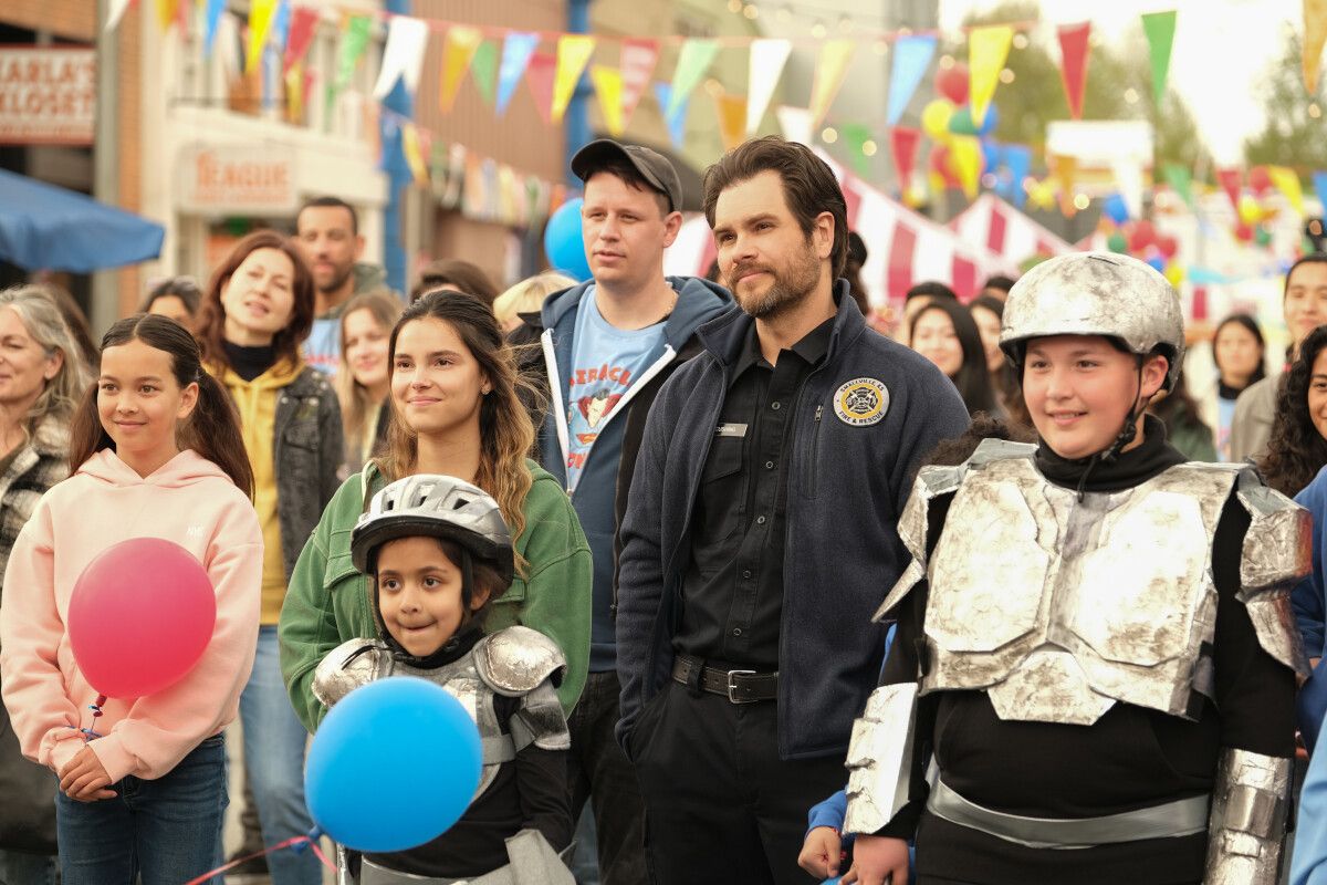 Erik Valdez as Kyle Cushing standing in a crowd with Inde Navarrette as Sarah in Superman and Lois season 2