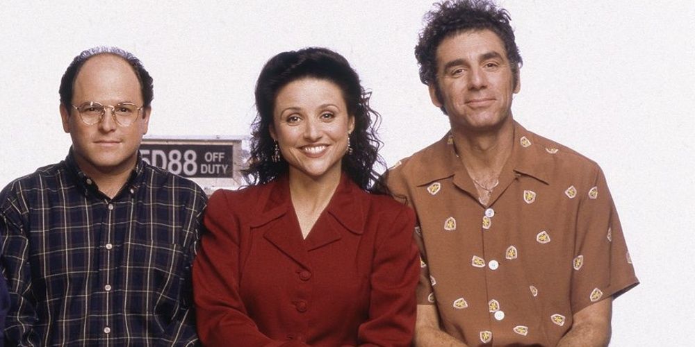 George, Elaine, and Kramer posing for a photo in Seinfeld 