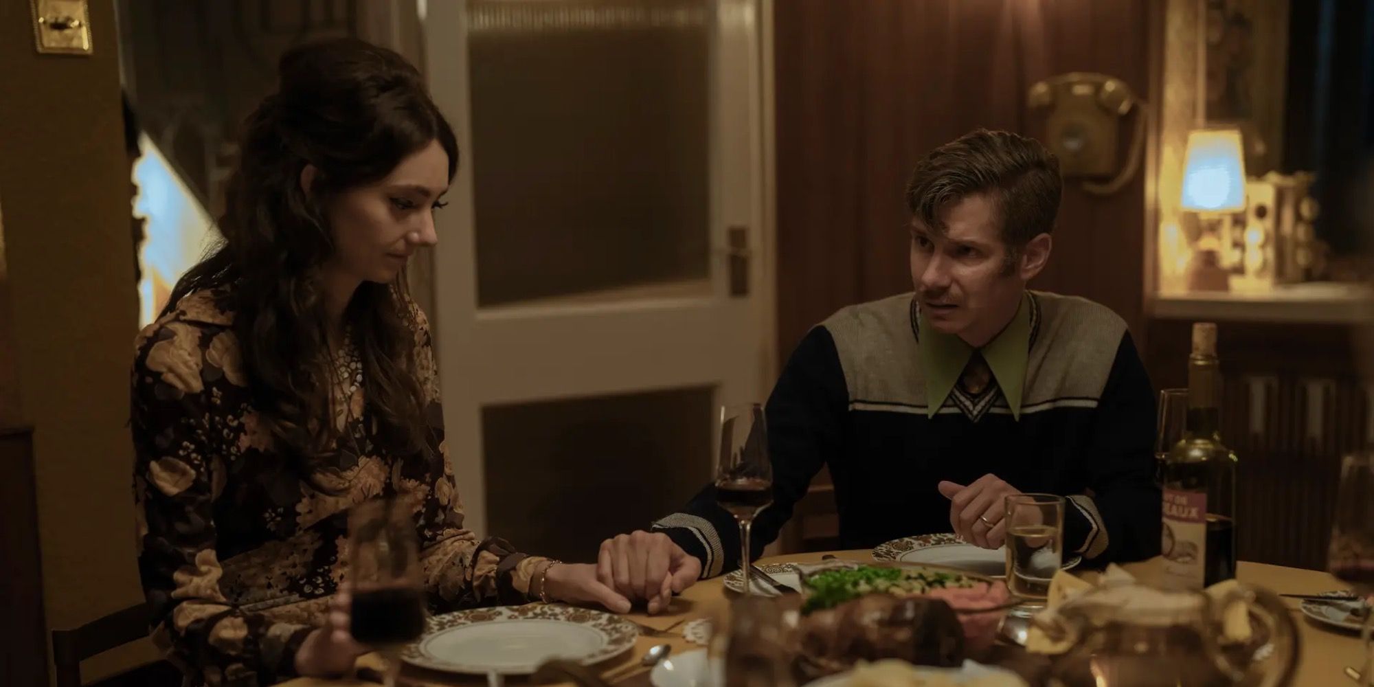 Image of Helen and Jack from HBO Max’s The Baby holding hands at the dinner table