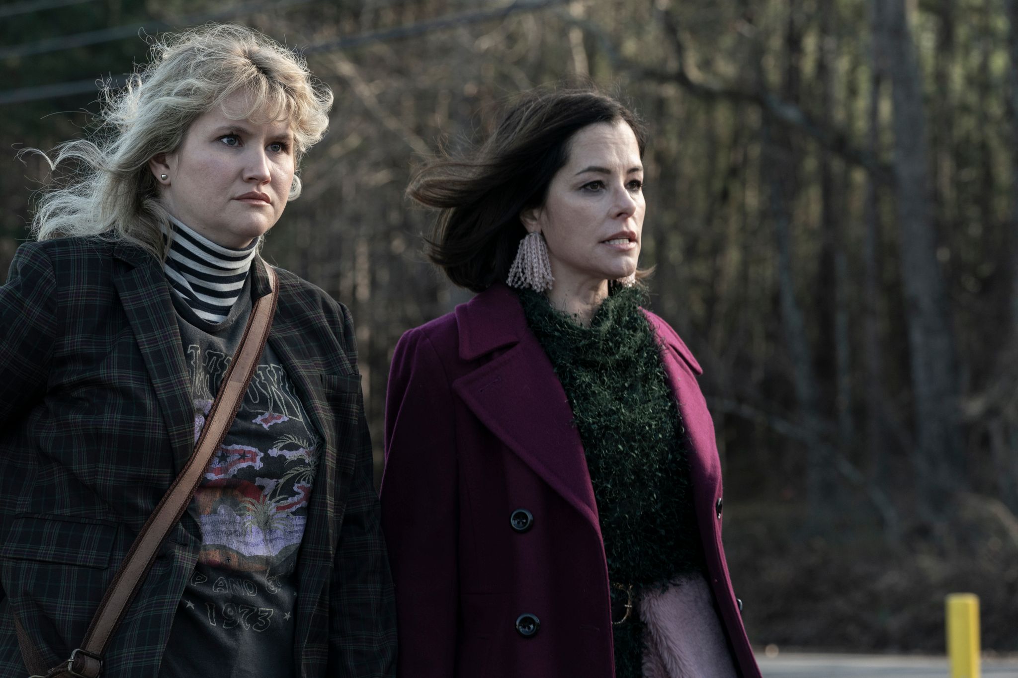 Jillian Bell as Gina and Parker Posey as Blair in character in Tales of the Walking Dead walking down a road in the forest