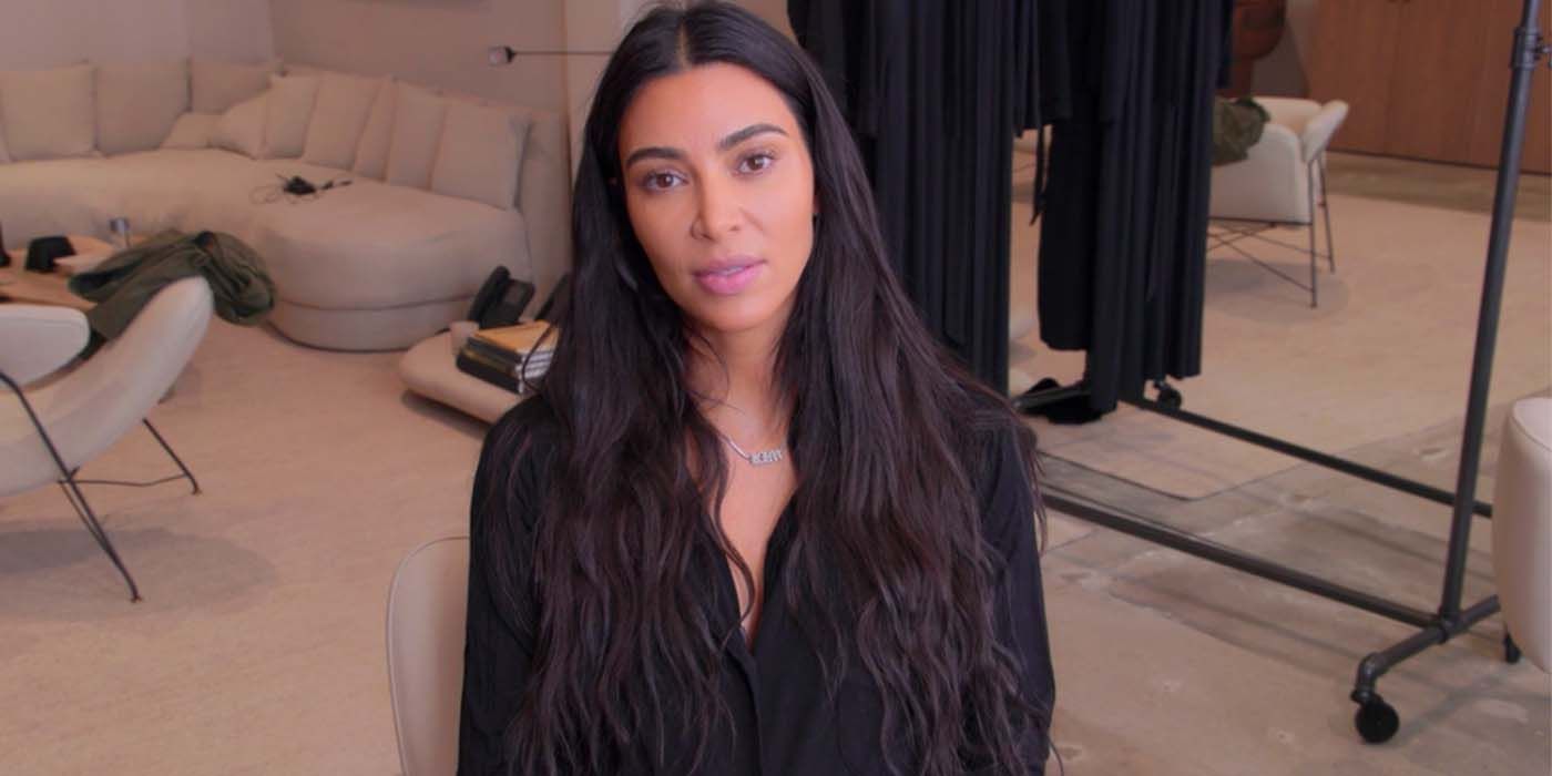 Kim Kardashian sobre The Kardashians usando blusa preta na sala de estar