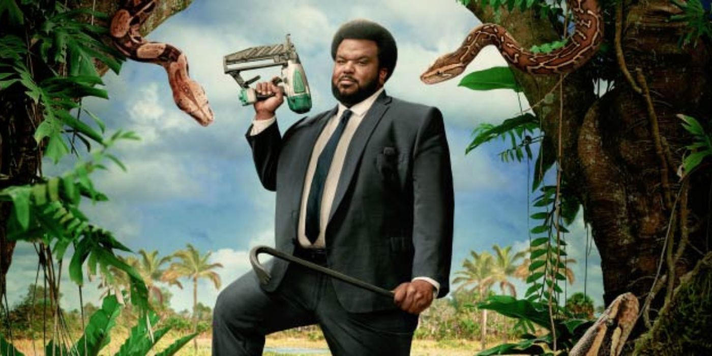 Craig Robinson holds a crowbar and nail gun in the jungle. 