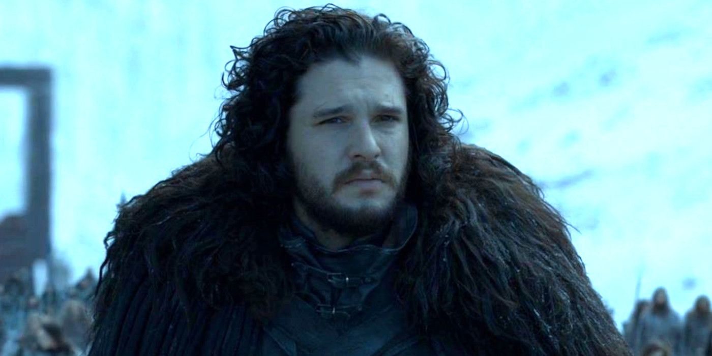 Kit Harington in character as Jon Snow in Game of Thrones season 8 wearing all black feathered uniform looking pensive