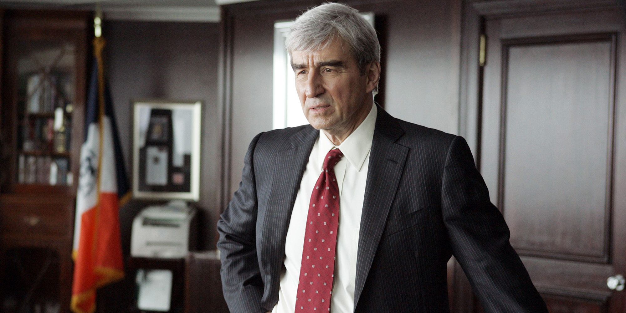 Sam Waterson as Jack McCoy standing in an office in Law and Order season 22