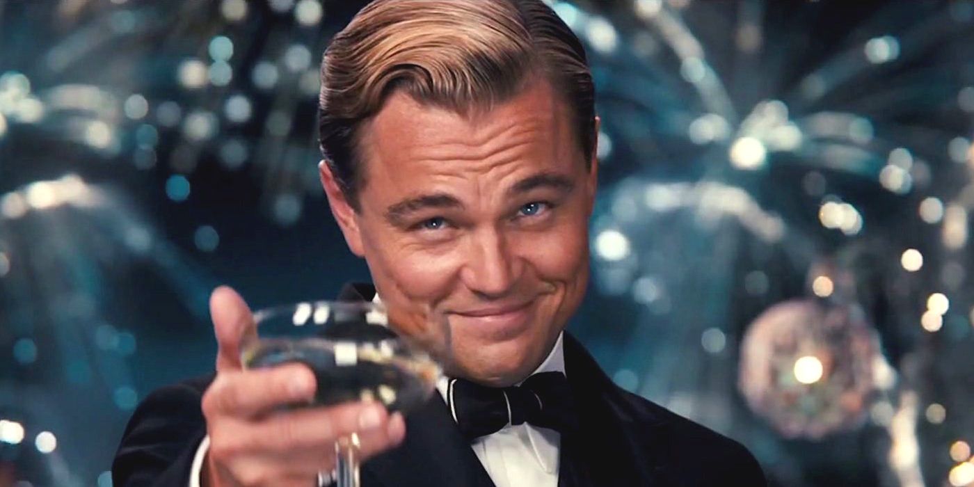Leonardo DiCaprio in character as Jay Gatbsy in The Great Gatsby offering a champagne toast while fireworks go off in the background