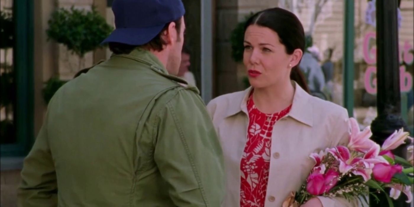 Lorelai talks to Luke outside while holding flowers on Gilmore Girls