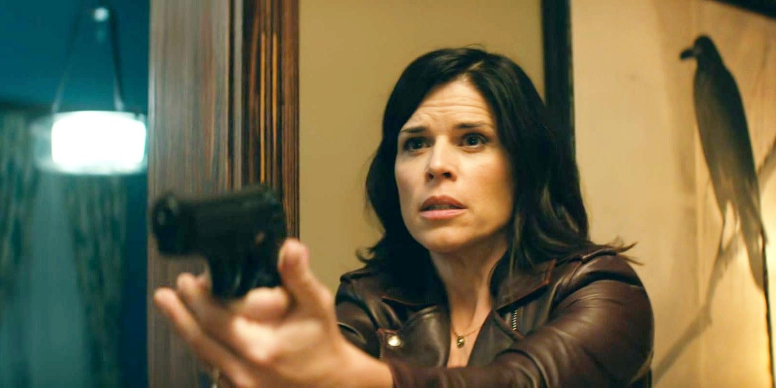 Neve Campbell holding a gun as Sidney in Scream 5.