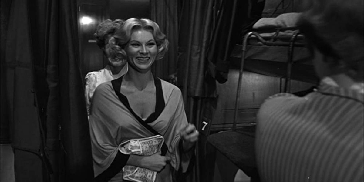 Grace Lee Whitney laughs while walking through a train car in Some Like It Hot 